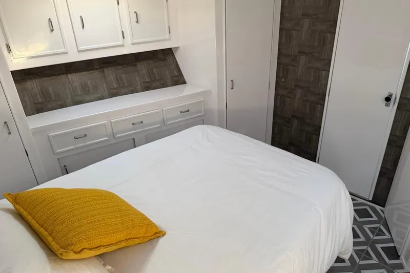 Slide: The Image of Interior of 1984 Ocean Yachts 55 Super Sport with white cabinetry and yellow pillow. - 32