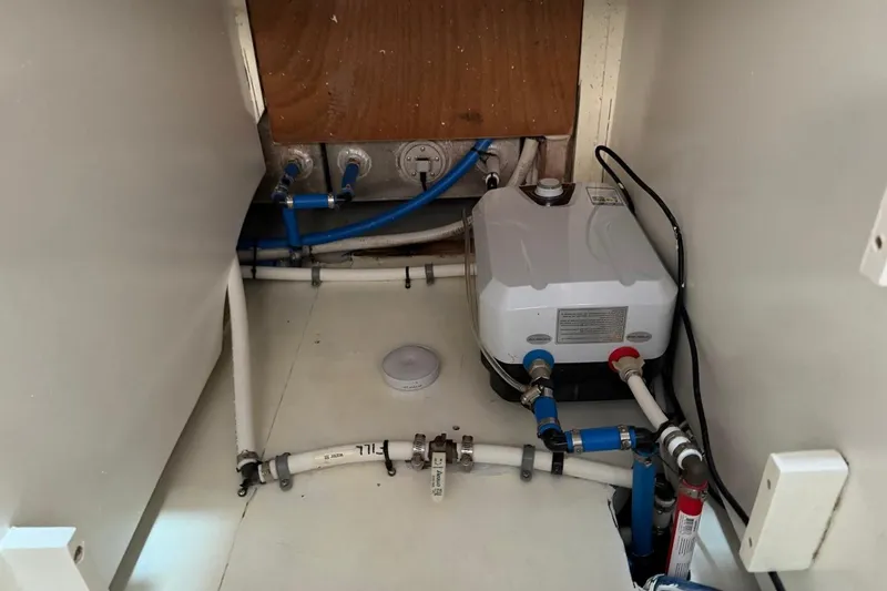 Slide: The Image of Engine room plumbing of 1984 Ocean Yachts 55 Super Sport, featuring pipes and connections. - 37