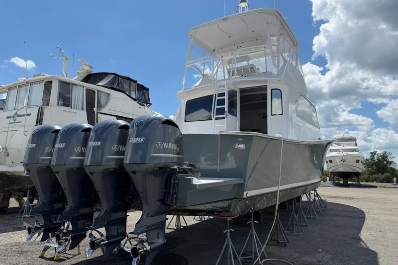 Slide: The Image of 1984 Ocean Yachts 55 Super Sport with Yamaha engines on stands, under a partly cloudy sky. - 4