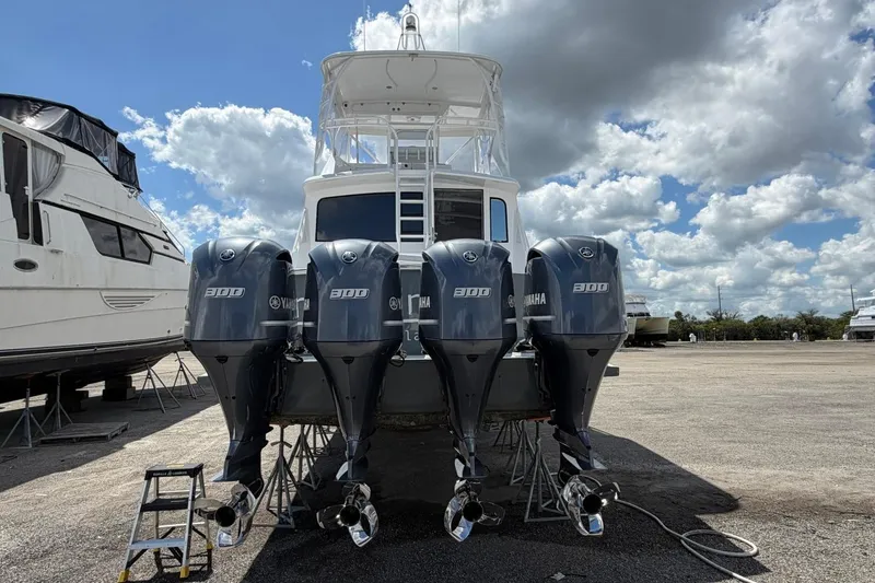 Slide: The Image of 1984 Ocean Yachts 55 Super Sport with four Yamaha 300 engines, docked under a cloudy sky. - 6