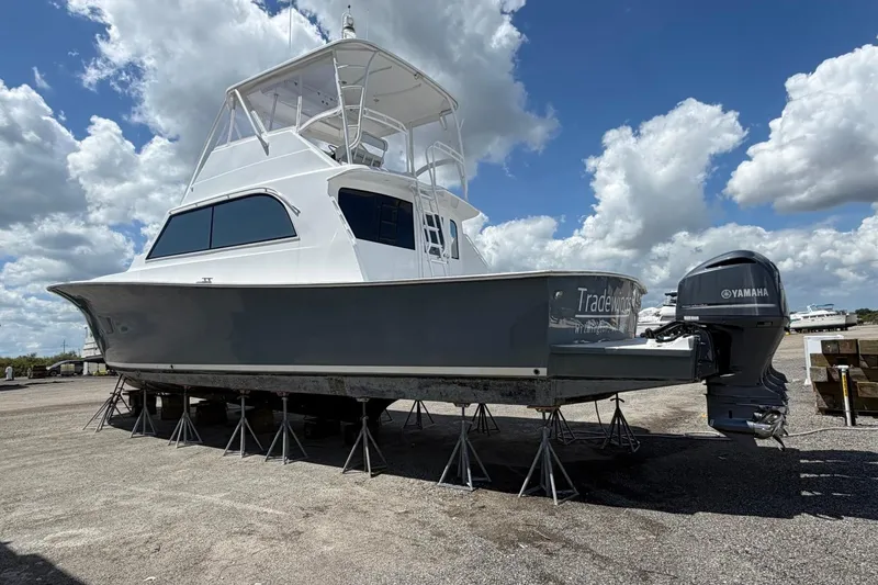 Slide: The Image of 1984 Ocean Yachts 55 Super Sport on stands, under a partly cloudy sky. - 7