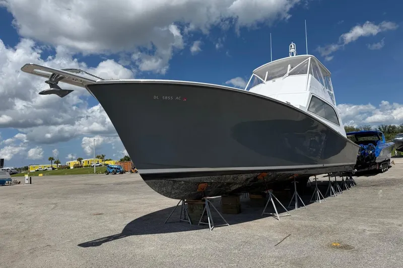 Slide: The Image of 1984 Ocean Yachts 55 Super Sport boat on stands under a blue sky. - 8