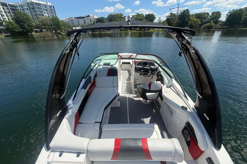 Slide: The Image of 2017 Regal 24 FasDeck boat interior with seating and steering, on a calm lake. - 4