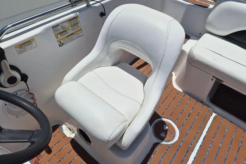 Slide: The Image of Captain's chair on 2013 Hurricane FunDeck 226 boat, featuring white upholstery and wood-patterned flooring. - 11