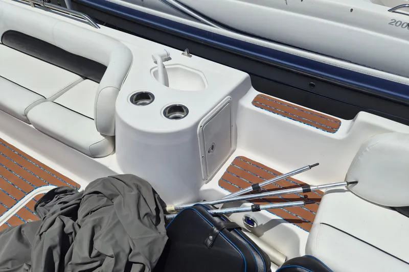 Slide: The Image of 2013 Hurricane FunDeck 226 interior with seating, cup holders, and fishing rods. - 14