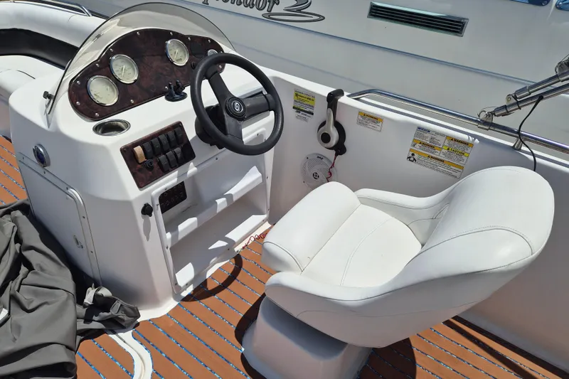 Slide: The Image of 2013 Hurricane FunDeck 226 boat cockpit with steering wheel and white captain's chair. - 9