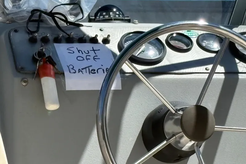 Slide: The Image of 2004 Trophy 1802 Walkaround boat dashboard with steering wheel and battery shut-off note. - 10