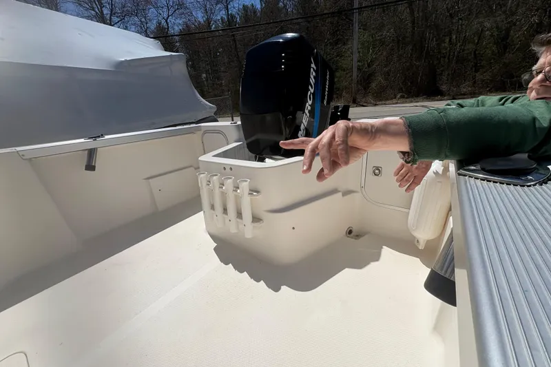 Slide: The Image of 2004 Trophy 1802 Walkaround boat interior with Mercury engine and rod holders. - 11