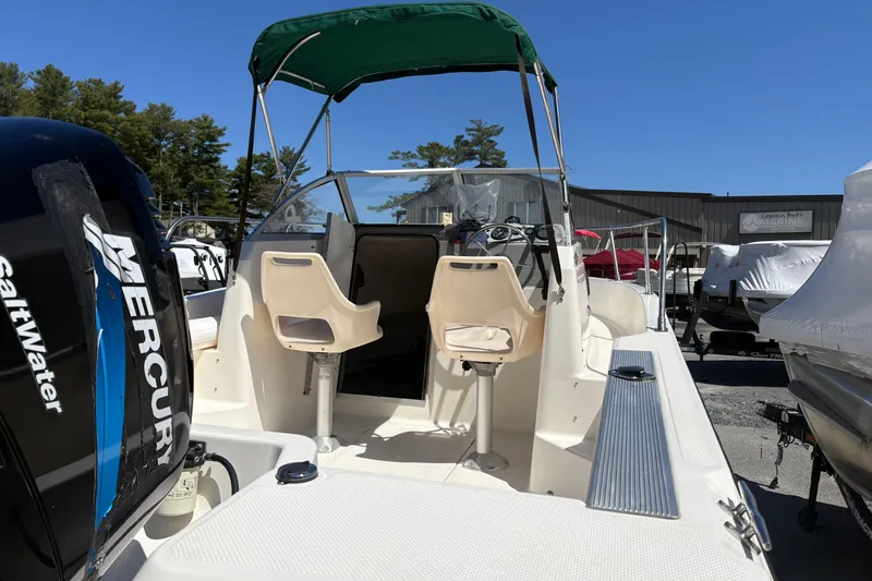 Slide: The Image of 2004 Trophy 1802 Walkaround boat with Mercury engine, featuring dual seats and green canopy. - 12