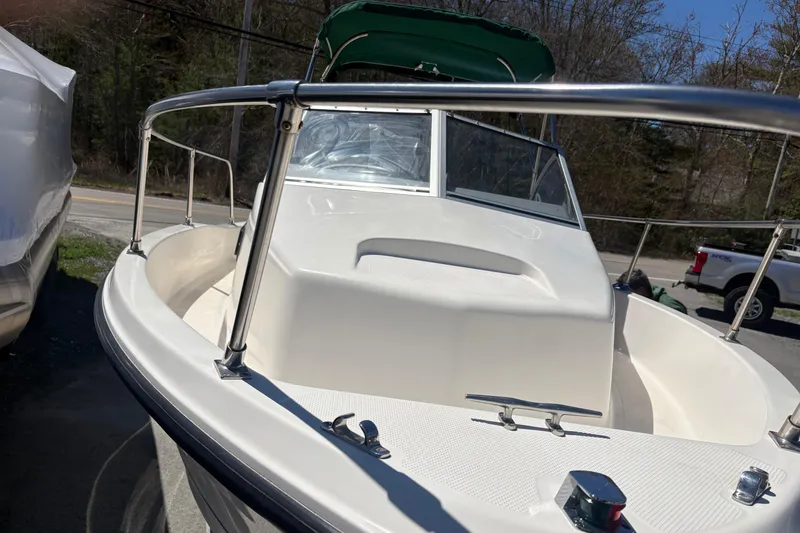 Slide: The Image of 2004 Trophy 1802 Walkaround boat with green canopy, docked outdoors. - 3