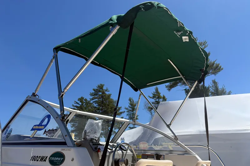 Slide: The Image of 2004 Trophy 1802 Walkaround boat with green canopy under clear blue sky. - 6