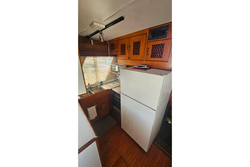 Slide: The Image of Compact kitchen in 1981 Sea Ranger 47 Pilothouse with wooden cabinets and appliances. - 10