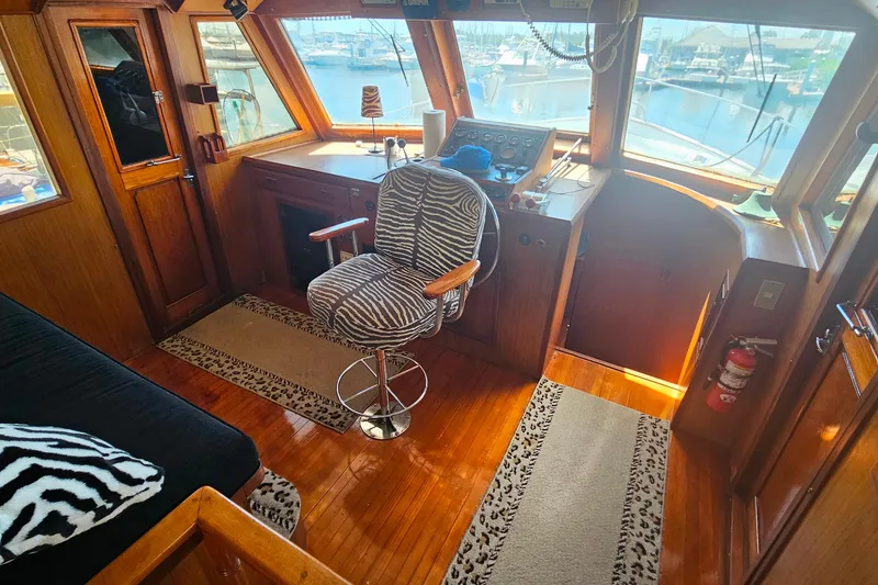 Slide: The Image of Pilothouse interior of 1981 Sea Ranger 47, featuring zebra-patterned chair and wooden accents. - 14