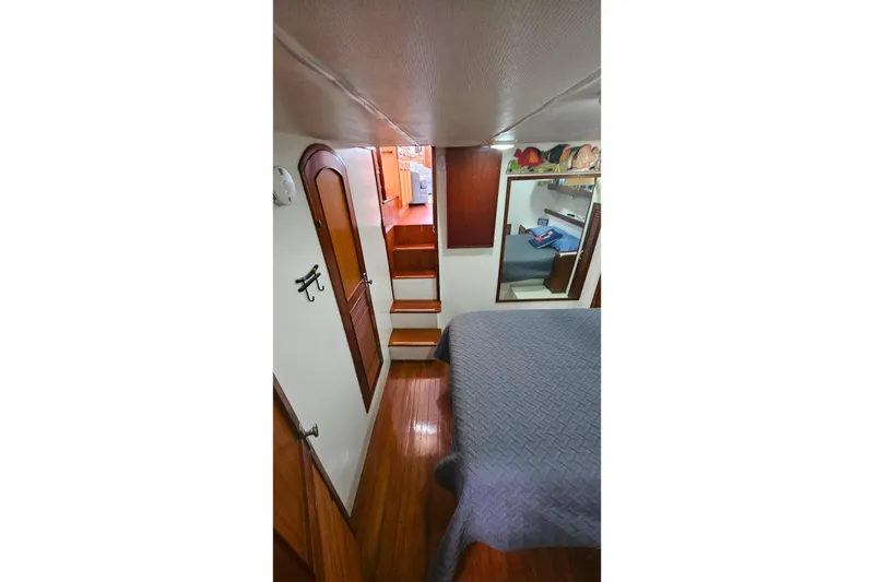 Slide: The Image of Interior of 1981 Sea Ranger 47 Pilothouse with wooden stairs and cozy bedroom. - 19
