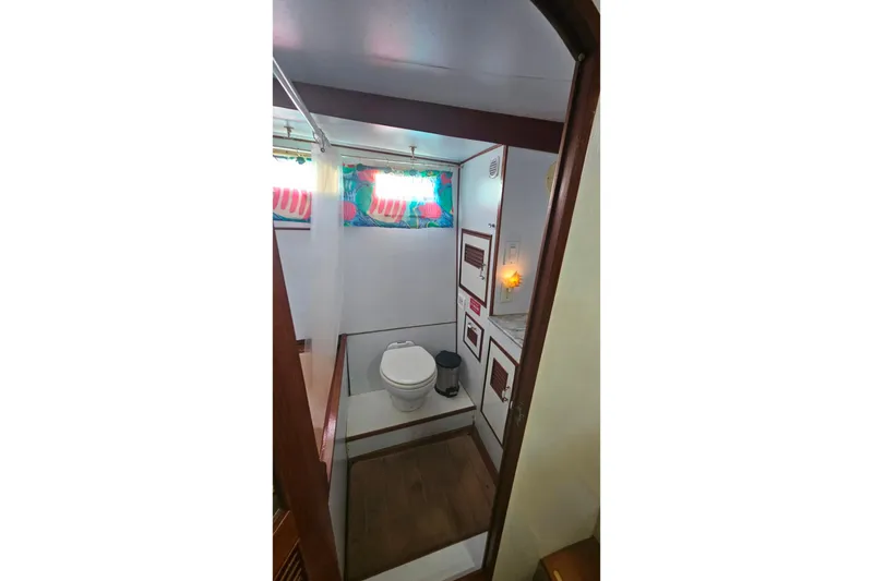 Slide: The Image of 1981 Sea Ranger 47 Pilothouse bathroom with colorful curtains and wooden accents. - 20