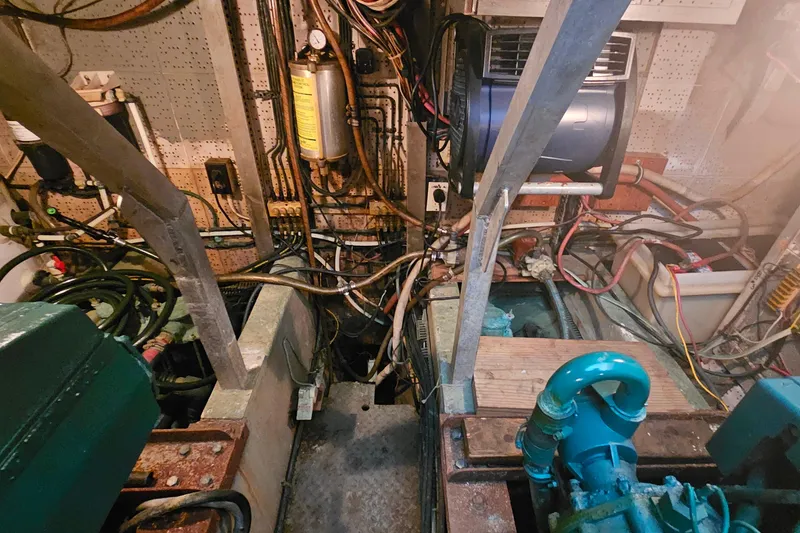 Slide: The Image of Engine room of a 1981 Sea Ranger 47 Pilothouse with visible machinery and wiring. - 29