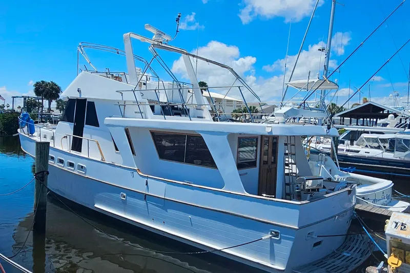 Slide: The Image of 1981 Sea Ranger 47 Pilothouse yacht docked at marina under blue sky. - 3