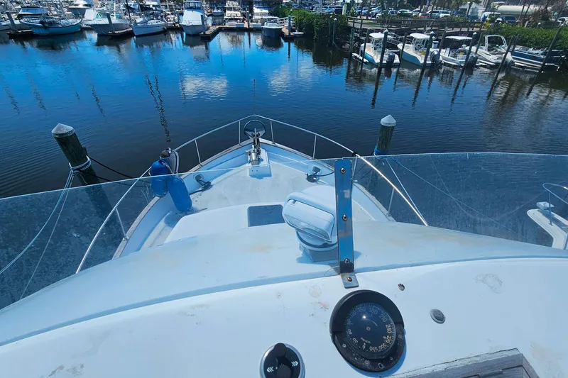 Slide: The Image of 1981 Sea Ranger 47 Pilothouse yacht docked in a marina, surrounded by boats. - 31