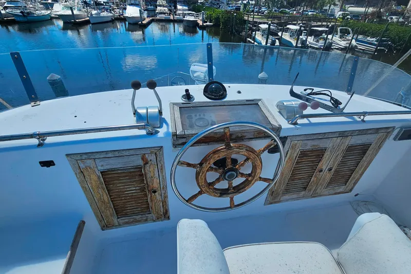 Slide: The Image of 1981 Sea Ranger 47 Pilothouse helm with wooden wheel, overlooking marina. - 34