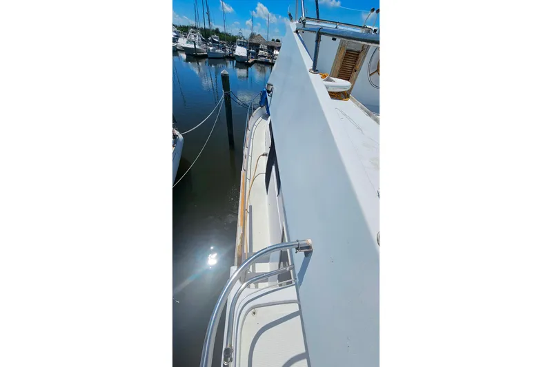 Slide: The Image of 1981 Sea Ranger 47 Pilothouse yacht docked in a marina under clear blue skies. - 38