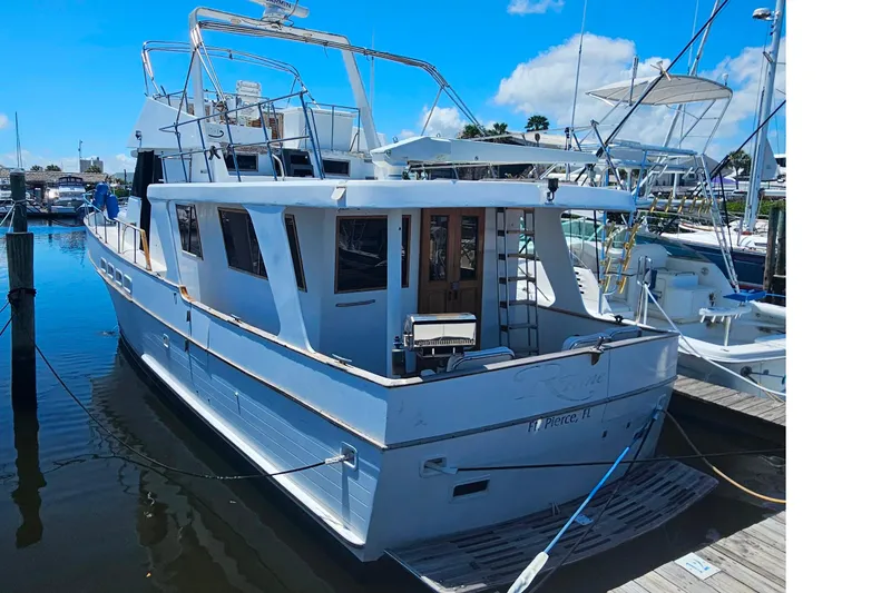 Slide: The Image of 1981 Sea Ranger 47 Pilothouse yacht docked at marina under clear blue sky. - 4