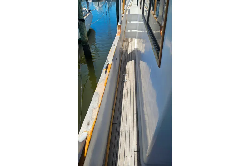 Slide: The Image of Side deck view of 1981 Sea Ranger 47 Pilothouse yacht docked at marina. - 40