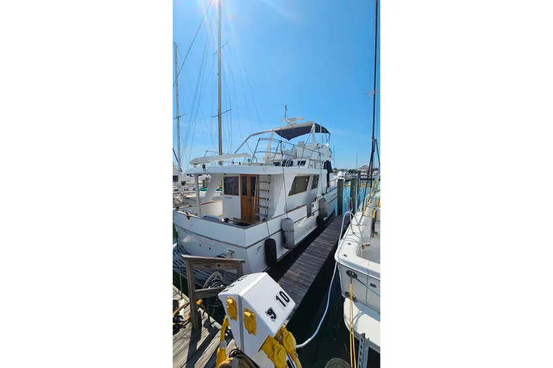 Slide: The Image of 1981 Sea Ranger 47 Pilothouse yacht docked at marina under clear blue sky. - 44