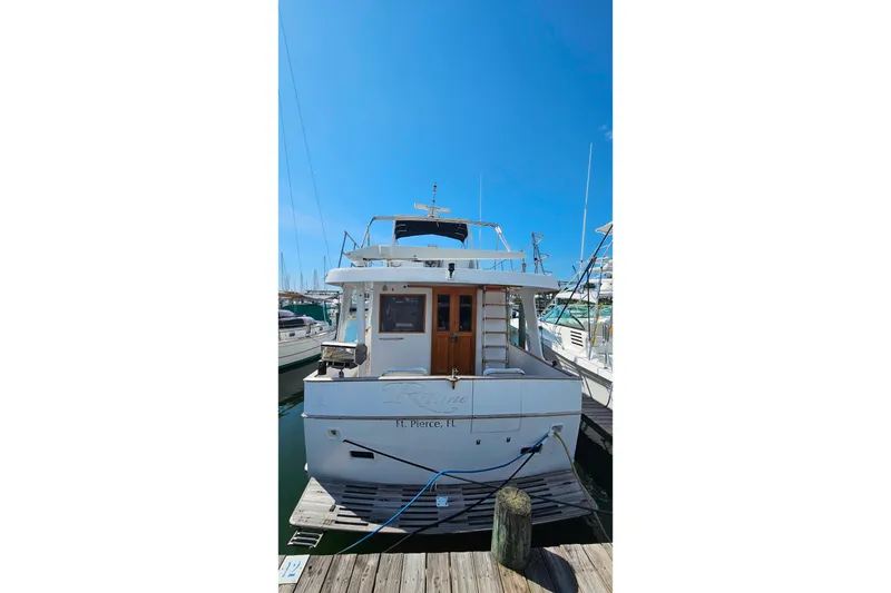 Slide: The Image of 1981 Sea Ranger 47 Pilothouse yacht docked at marina under clear blue sky. - 45