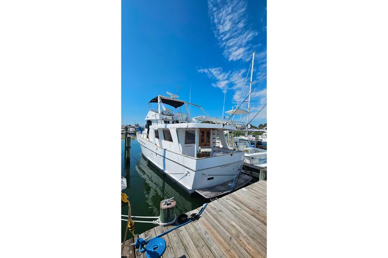 Slide: The Image of 1981 Sea Ranger 47 Pilothouse yacht docked at marina under clear blue sky. - 46