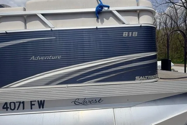 Slide: The Image of 2019 Quest Adventure 818 pontoon boat with blue and white design, docked outdoors. - 10