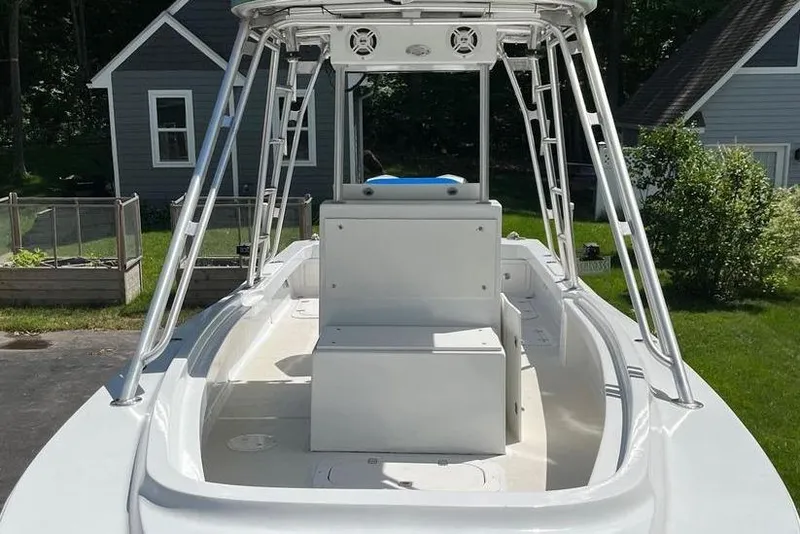 Slide: The Image of 1974 Boca Grande Passmaster 26 boat with T-top and seating, parked in a residential yard. - 11