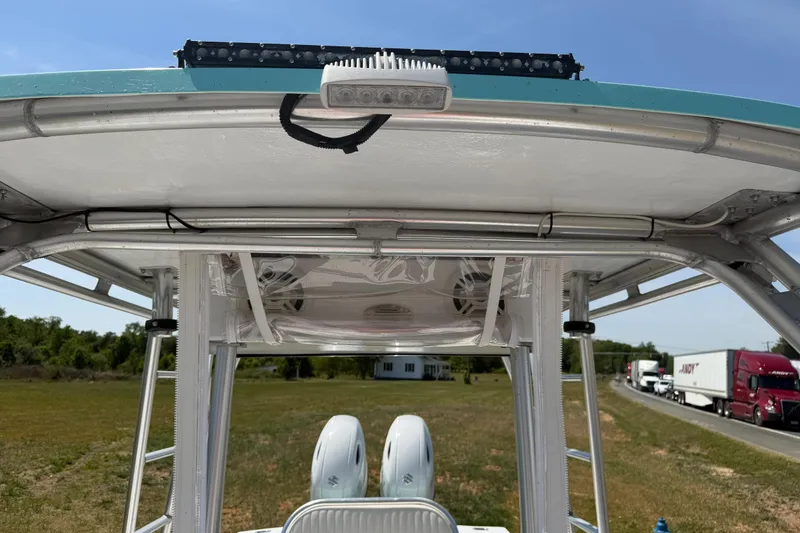 Slide: The Image of 1974 Boca Grande Passmaster 26 boat with T-top and dual engines, parked near highway. - 13
