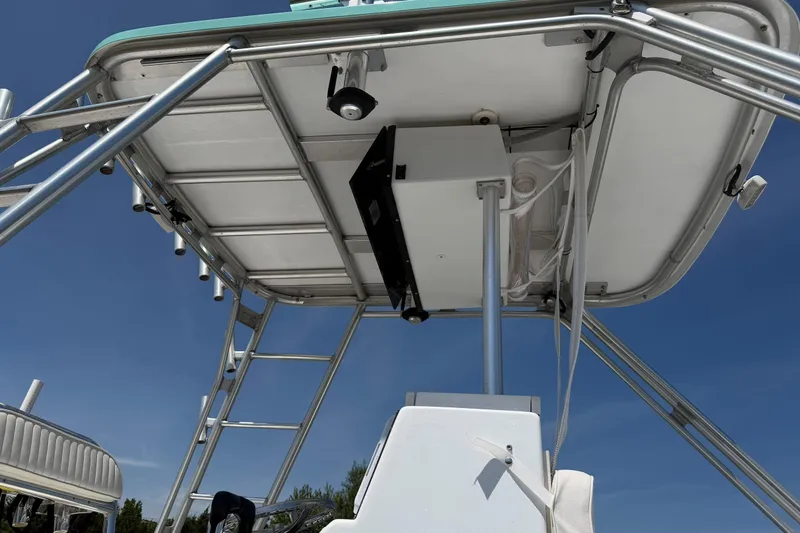 Slide: The Image of 1974 Boca Grande Passmaster 26 boat with metal framework and canopy against blue sky. - 14