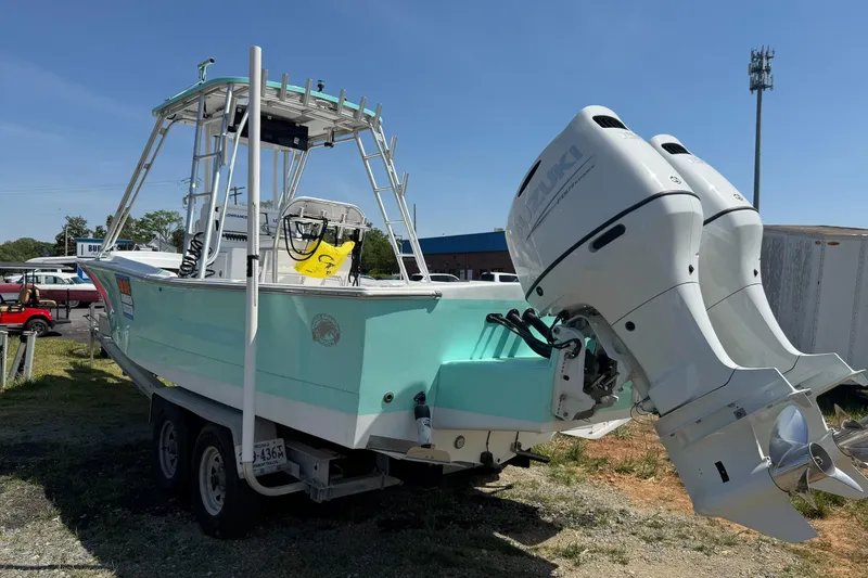 Slide: The Image of 1974 Boca Grande Passmaster 26 boat with dual Suzuki outboard motors on a trailer. - 2