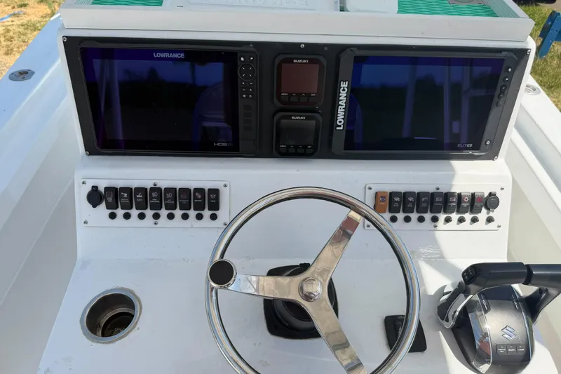 Slide: The Image of 1974 Boca Grande Passmaster 26 boat dashboard with steering wheel and navigation controls. - 22