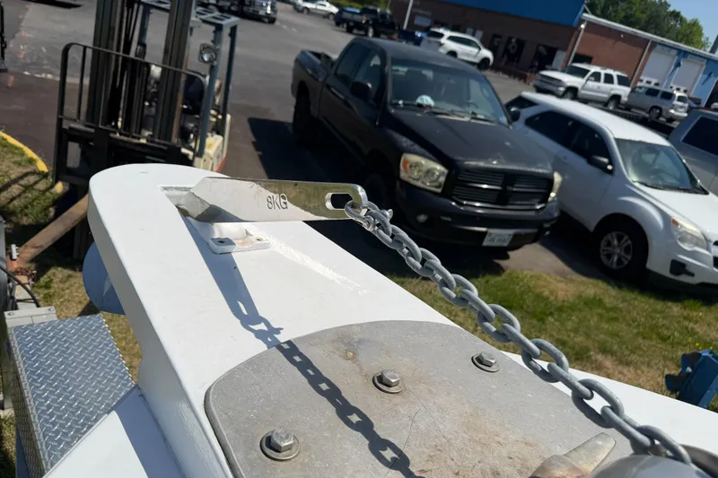 Slide: The Image of Bow of a 1974 Boca Grande Passmaster 26 with anchor chain, parked vehicles in background. - 28