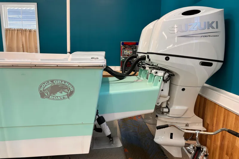 Slide: The Image of 1974 Boca Grande Passmaster 26 with Suzuki outboard motor in a showroom setting. - 4