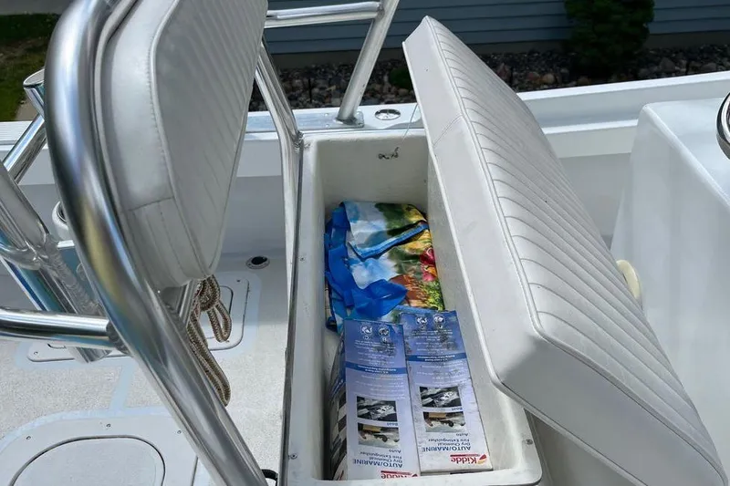 Slide: The Image of Open storage compartment on a 1974 Boca Grande Passmaster 26 boat with brochures inside. - 9