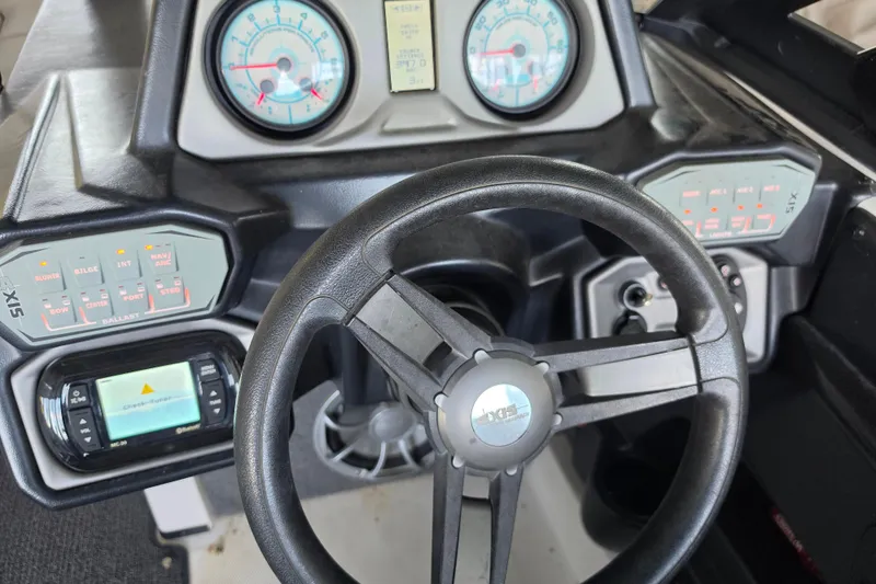 Slide: The Image of Steering wheel and dashboard of a 2017 Axis T23 boat with control panels. - 16