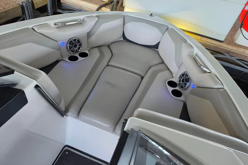Slide: The Image of 2017 Axis T23 boat interior with cushioned seating, cup holders, and speakers. - 19