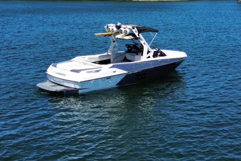 Slide: The Image of 2017 Axis T23 boat on calm blue water, featuring a sleek design and wakeboard tower. - 3