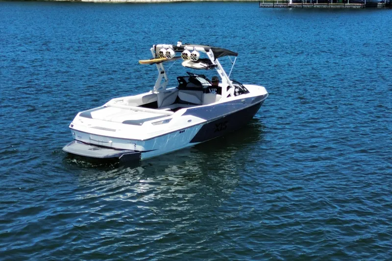 Slide: The Image of 2017 Axis T23 boat on a calm lake, featuring a sleek design and wakeboard tower. - 4