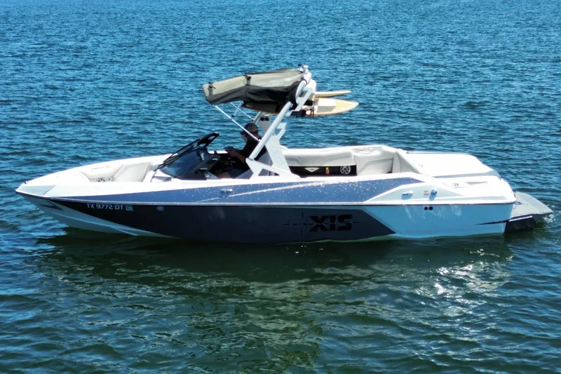 Slide: The Image of 2017 Axis T23 boat on calm blue water, featuring sleek design and wakeboard tower. - 5