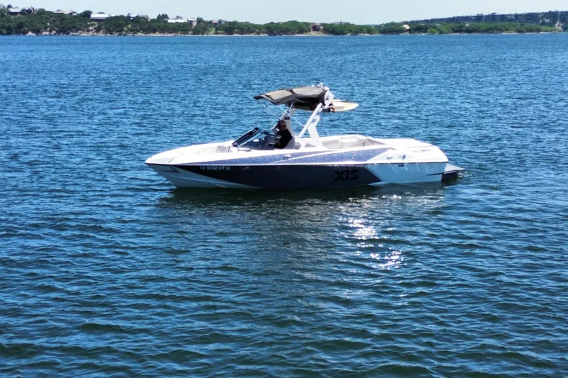 Slide: The Image of 2017 Axis T23 boat floating on a calm lake under clear skies. - 6