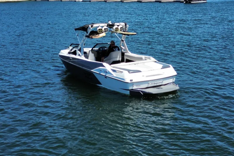 Slide: The Image of 2017 Axis T23 boat on a calm lake, featuring a sleek design and wakeboard tower. - 8