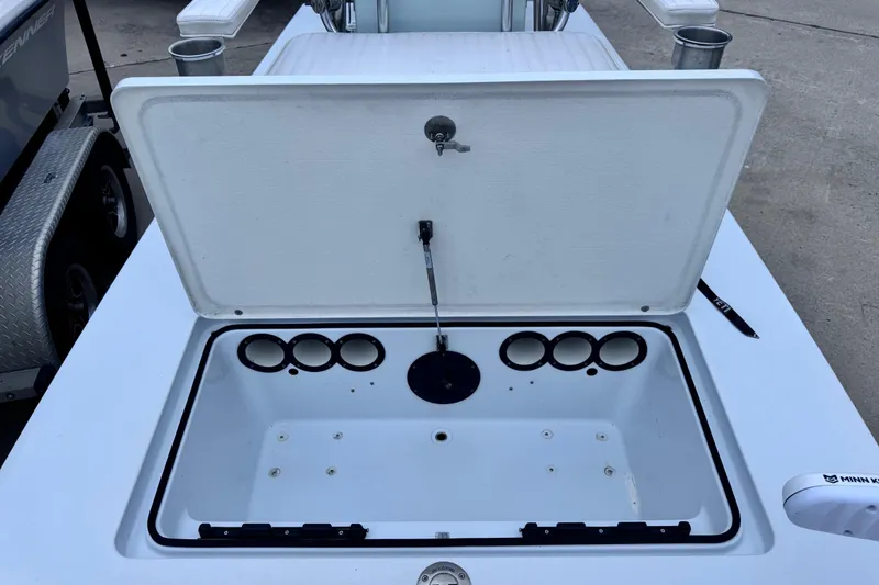 Slide: The Image of Open storage compartment on a 2016 East Cape Fury boat, featuring cup holders. - 19