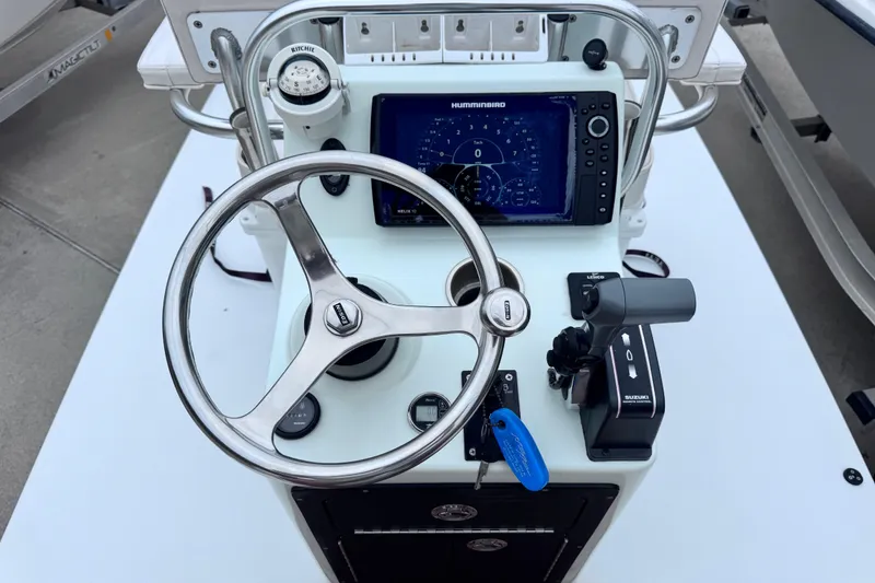 Slide: The Image of 2016 East Cape Fury boat console with steering wheel, Humminbird display, and Suzuki controls. - 23