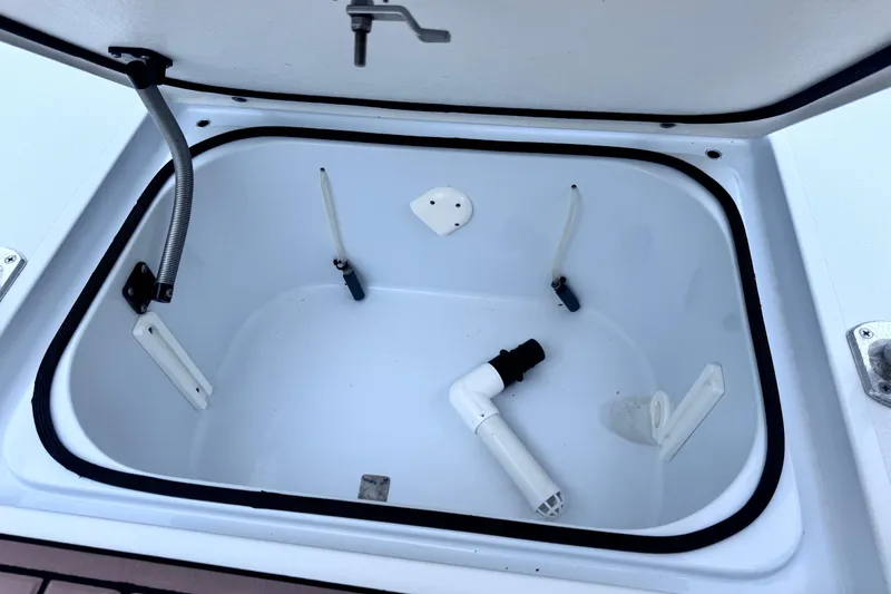 Slide: The Image of Open storage compartment in 2016 East Cape Fury boat, featuring plumbing components. - 28