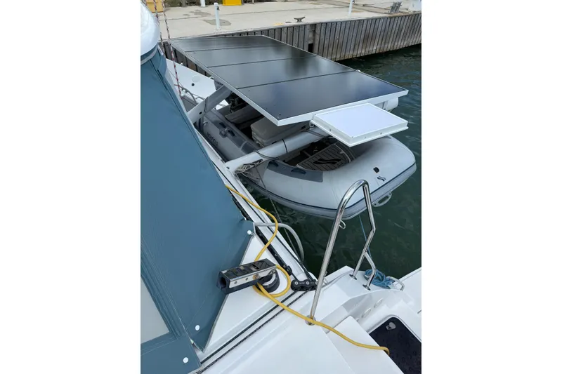 Slide: The Image of 2022 Outremer 51 catamaran with solar panels and dinghy at dockside. - 11