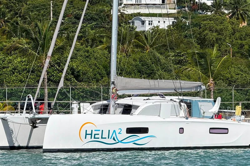 Slide: The Image of 2022 Outremer 51 catamaran "HELIA²" docked near lush tropical greenery. - 29